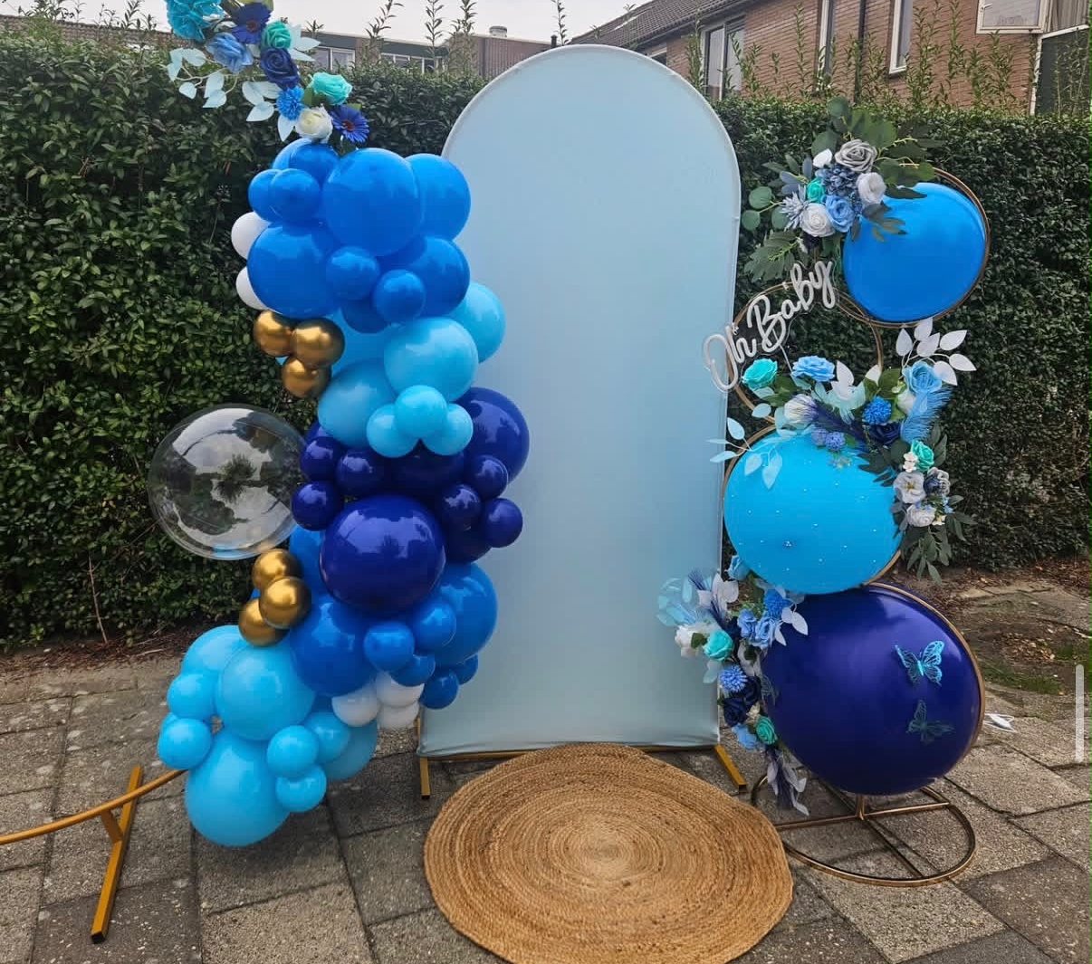 Babyshower-backdrop in blauwtinten met cirkelframes en bloemen